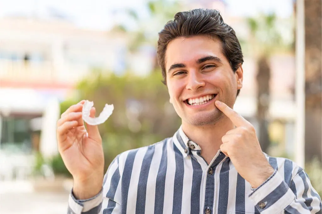 Happy young man showing his Invisalign