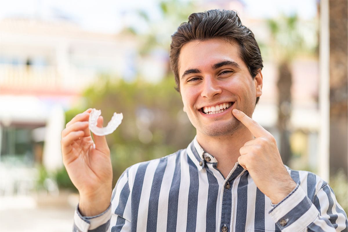 Happy young man showing his Invisalign