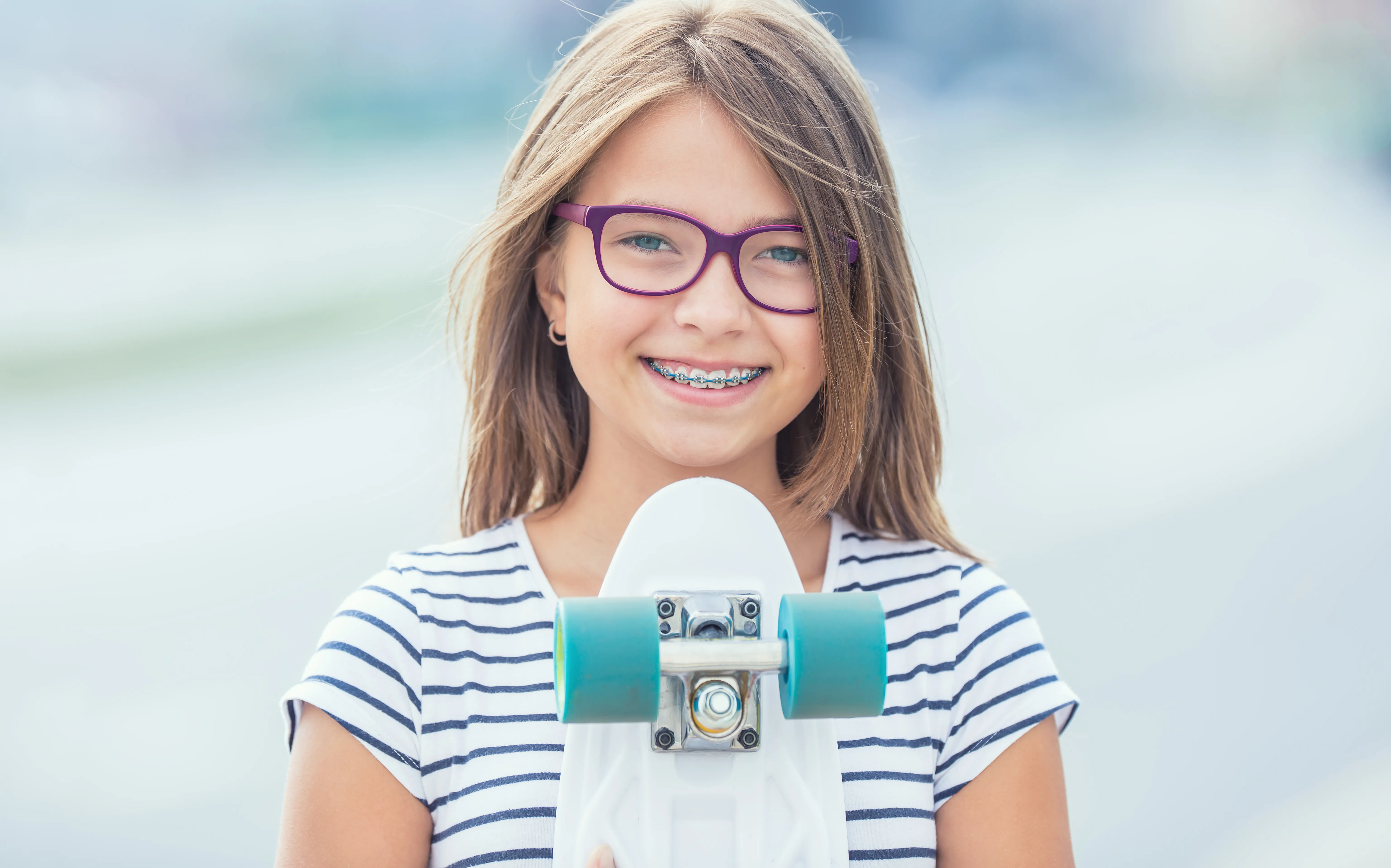 Portrait of happy smiling girl with dental braces and glasses.